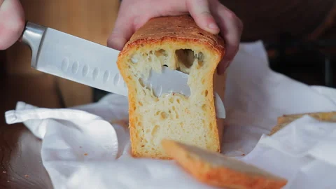 Slicing fresh homemade bread, soft airy texture with a golden crispy crust Video stock 303933542