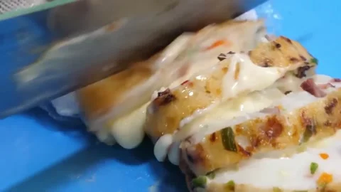 Slicing Fresh Korean Fish Cake (Eomuk) on Blue Cutting Board Stock Footage 337374685