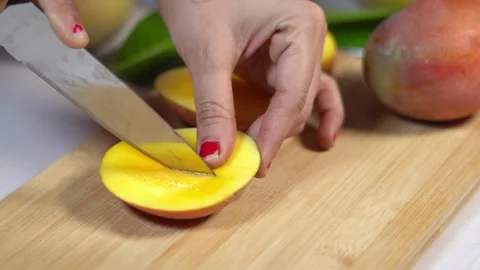 Slicing Fresh Mango Halves with Knife on Wooden Cutting Board Close Up. 스톡 동영상 336686776