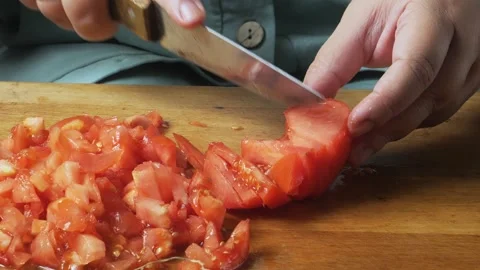 Slicing fresh red tomatoes with a knife on a cutting board on a wooden tabl.. Video stock 344885469