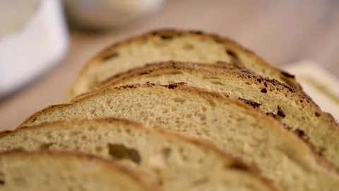 Slicing a Freshly Baked Artisan Bread Loaf on a Wooden Cutting Board for Stock Footage 295515405