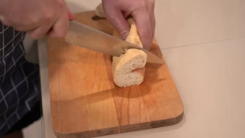 Slicing Freshly Baked Bread: A Step-by-Step Visual Guide to Cutting a Loaf into Stock Footage 321051184
