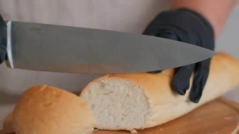 Slicing Freshly Baked Bread with a Very Sharp Knife for Delicious Culinary Stock-Footage 305889547