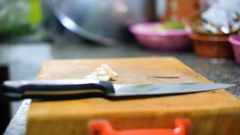 Slicing garlic  on cutting board to prepare ingredient for cooking Stock Footage 100743952