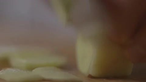 Slicing ginger root on cutting board with a knife Stock Footage 194478560