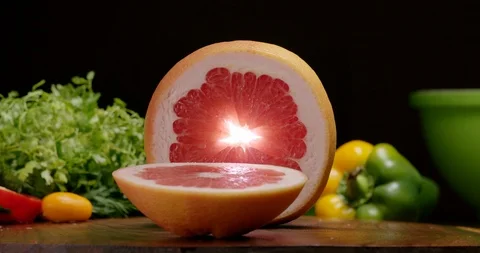 Slicing grapefruit with kitchen knife to cook vitamins salad with fruits. Stock Footage 125599917