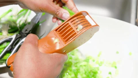 Slicing Green Onions with Orange Multi Blade Kitchen Scallion Cutter Stock Footage 345858161