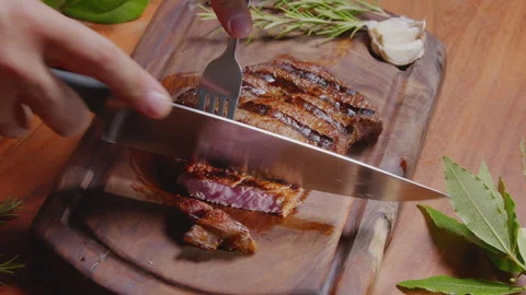 Slicing grilled beef ribeye steak medium rare with knife and fork Vídeos de archivo 340507277