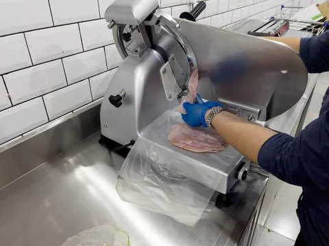 Slicing ham in a slicer machine Stock Photos