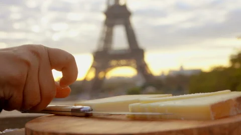 Slicing hard goat cheese on backdrop Eiffel Tower Stock Footage 118505984