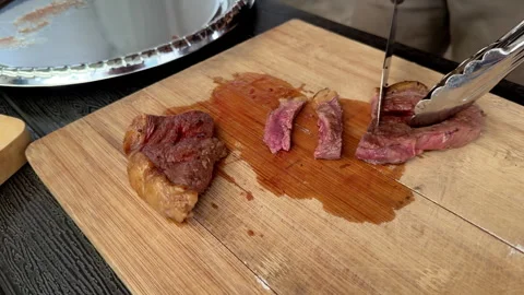 Slicing juicy grilled medium rare steak on wooden cutting board. Stock Footage 337227221