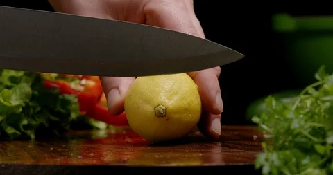 Slicing lemon on a cutting board in kitchen Stock Footage 125726322