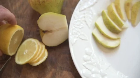 Slicing lemons and pears and plating onto a white platter 스톡 동영상 76889079