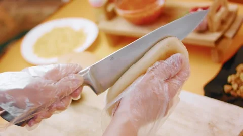 Slicing lengthwise through a bread roll for a hot dog, 4K Stock Footage 341121860