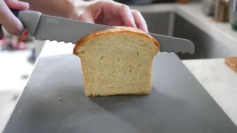 Slicing a loaf of bread on a cutting board Stock Footage 246840814