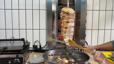 Slicing meat from shawarma grill Stock Footage 318912188