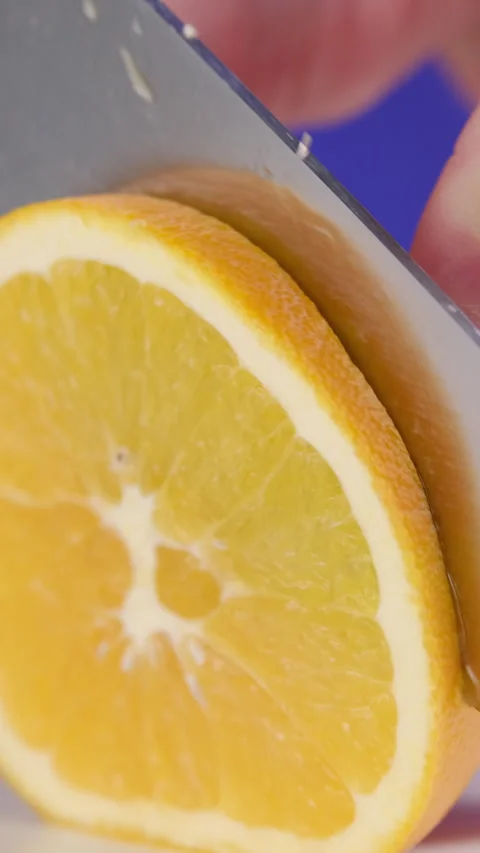 Slicing an Orange into Halves with a Knife Stock Footage 302507381
