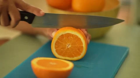 Slicing the Orange in the kitchen table Stock Footage 260628983