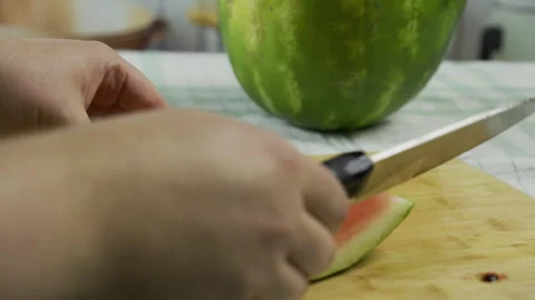 Slicing up part of a watermelon with large knife - slow, closeup shot Stock Footage 341225334