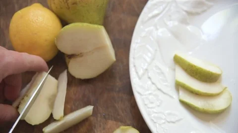 Slicing pear and placing slices onto a platter 스톡 동영상 76889063