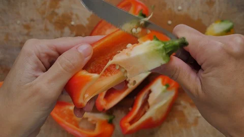 Slicing pepperoni, vegetable cooking, preparation of yellow and red peppers.  Stock Footage 118971643