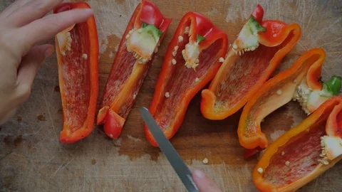 Slicing pepperoni, vegetable cooking, preparation of yellow and red peppers.  Stock Footage 118972187
