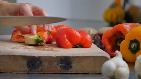 Slicing pepperoni, vegetable cooking, preparation of yellow and red peppers.  Stock Footage 118972253