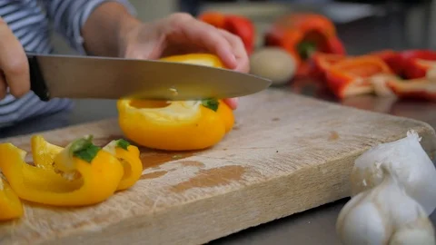 Slicing pepperoni, vegetable cooking, preparation of yellow and red peppers.  Stock Footage 118972278