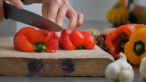 Slicing pepperoni, vegetable cooking, preparation of yellow and red peppers.  Stock Footage 118972635