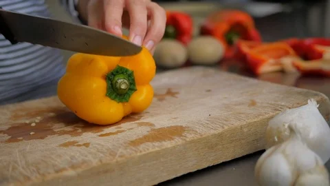 Slicing pepperoni, vegetable cooking, preparation of yellow and red peppers.  Stock Footage 118972860