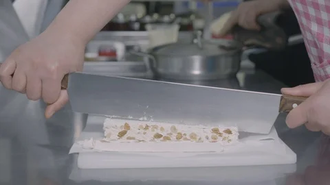 Slicing a piece of a torrone Stock Footage 129993376