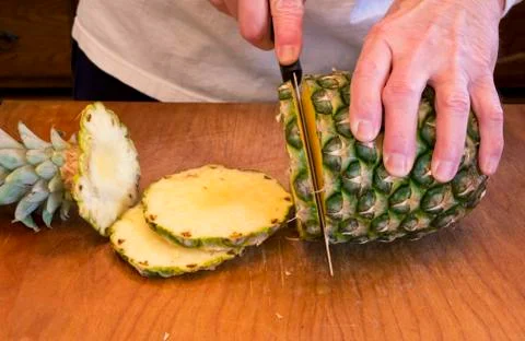 Slicing a pineapple 库存照片