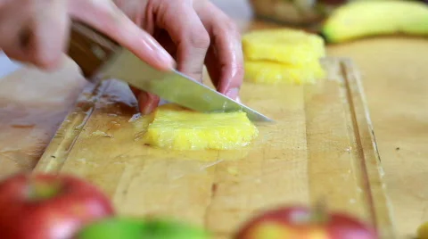 Slicing pineapple - Preparing fruit salad close-up Stock Footage 719624