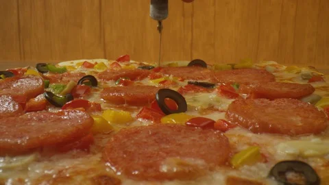 Slicing a pizza into slices with a pizza cutter Stock Footage 129727700