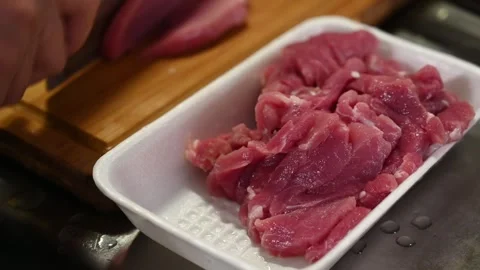 Slicing Pork Loin into Thin Strips for Cooking Stock Footage 346487801