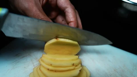 Slicing a Potato on Cutting Board, Close-up of hands slicing a peeled potat.. Vídeos de archivo 304978601