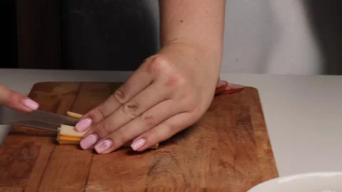 Slicing processed cheese with kitchen knife on wooden cutting board. preparing Video stock 316472691