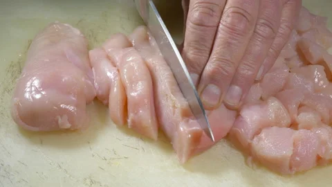 Slicing raw chicken breasts. Stock Footage 135303032