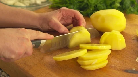 Slicing raw peeled potatoes with a kitchen knife Stock Footage 331313990