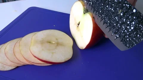 Slicing a red apple on a blue plank. Stock Footage 150443347