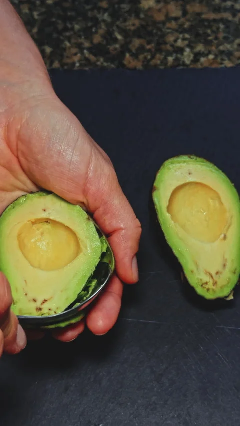Slicing a ripe avocado in hand Stock Footage 277726653