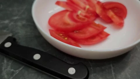 Slicing ripe red tomatoes for a fresh summer salad in a bright kitchen Stock Footage 336202991
