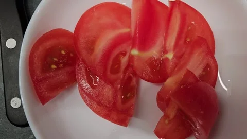 Slicing ripe tomatoes for a fresh and colorful salad creation Stock Footage 336202984