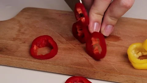 Slicing small red sweet pepper on wooden cutting board. Preparing fresh pepper Stock Footage 304759185