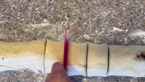 Slicing Stuffed Pastry Dough Log into Portions Stock Footage 345522444