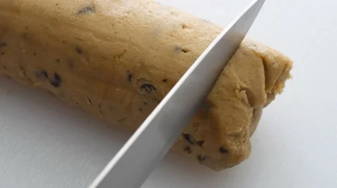 Slicing thawed cookie dough on a cutting board Stock Footage 63225603