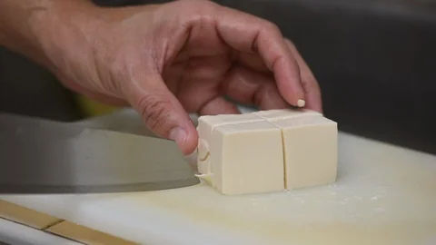 Slicing tofu on white board Stock Footage 97116773