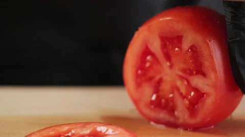 Slicing a tomato with a knife. Video stock 151645530