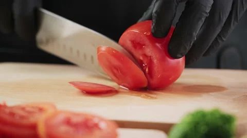 Slicing a tomato with a knife. Vídeo Stock 153543868