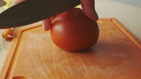 Slicing tomatoes on a cutting board Vídeos de archivo 134556137